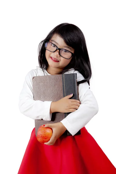 Söt flicka håller en bok och apple — Stockfoto