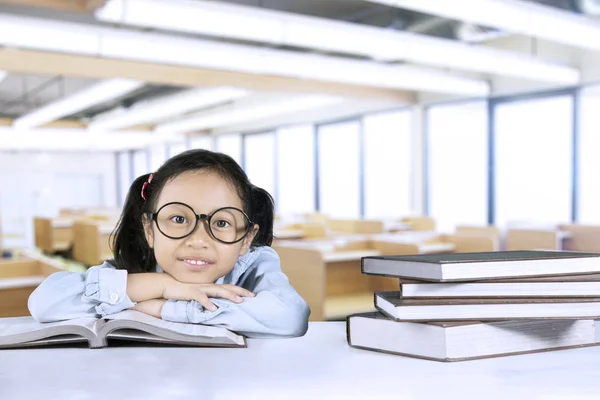 Schattig meisje zit met boeken in de klas — Stockfoto