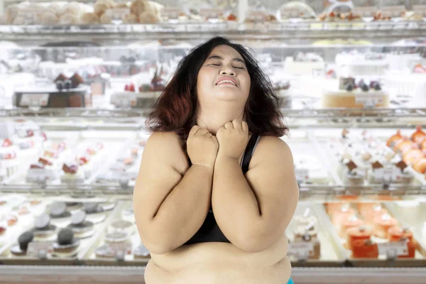 Dikke vrouw depressief in de taart winkel — Stockfoto