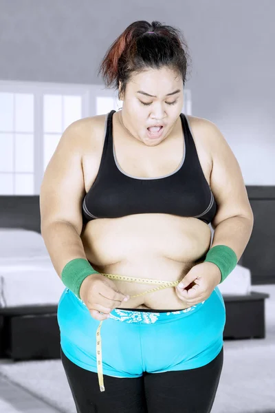 Fat woman measuring her waist — Stock Photo, Image