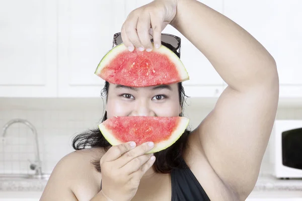 Dikke vrouw met watermeloen in keuken — Stockfoto