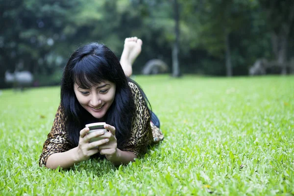 Chica mensajes de texto en el parque —  Fotos de Stock