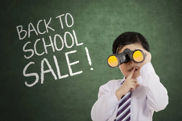 Niño pequeño con binocular en el aula — Foto de Stock