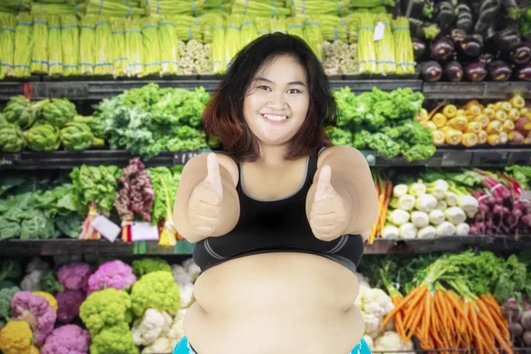 Mujer con sobrepeso en la tienda de verduras — Foto de Stock