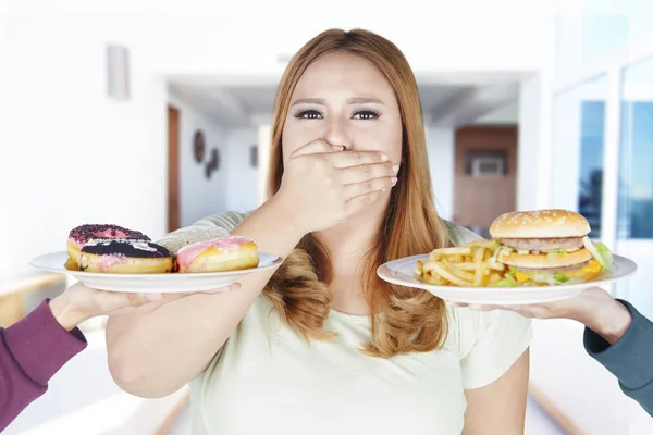 Толстая женщина отказывается от калорийной пищи — стоковое фото