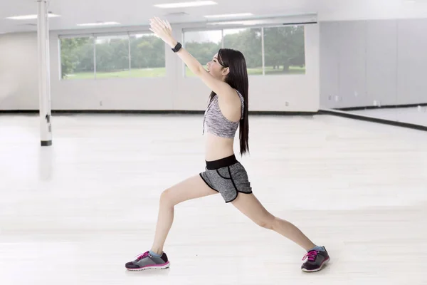 Smal kvinna gör warm-up på gym — Stockfoto
