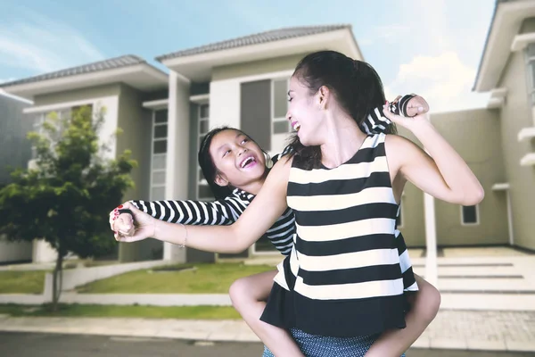 Woman and daughter with their new house — Stock Photo, Image