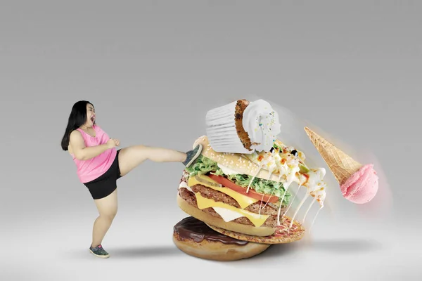 若い女性の不健康な食品を蹴る — ストック写真
