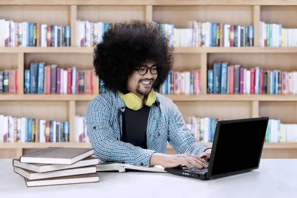 Afro öğrenci Kitaplığı'nda bir dizüstü bilgisayar kullanarak