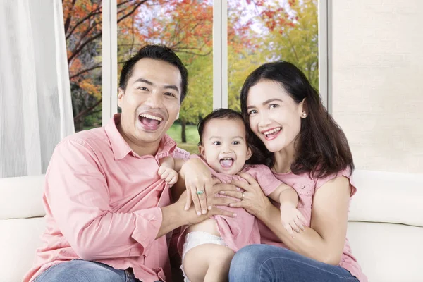 Hija y padres riendo en el sofá — Foto de Stock