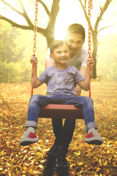 Vater und Kind spielen auf einer Schaukel — Stockfoto