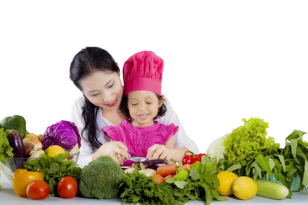 Mãe e chef bonito cortando uma berinjela — Fotografia de Stock