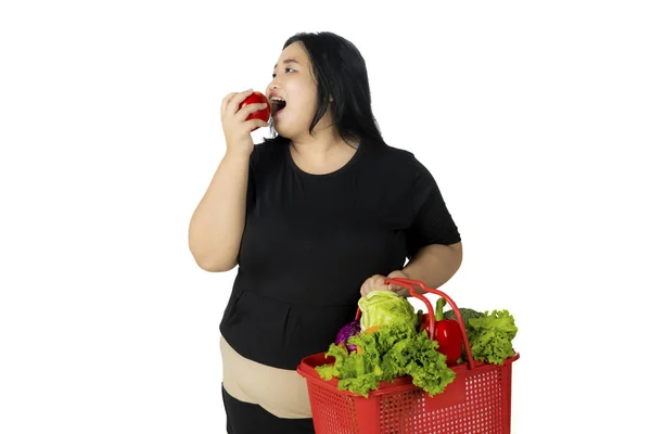 Mujer con sobrepeso comiendo una manzana después de comprar — Foto de Stock