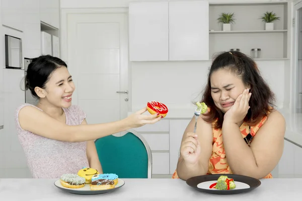 Obézní žena odmítá jíst koblihy — Stock fotografie