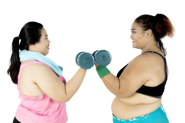 Избыточный вес женщин, тренирующихся с гантелями — стоковое фото
