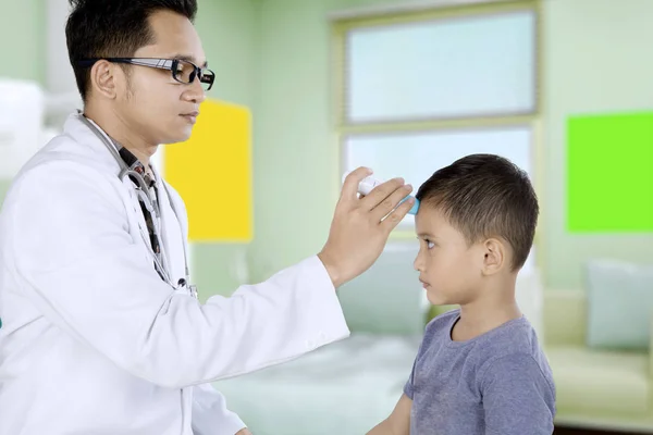 Kinderarts met behulp van een digitale thermometer voor patiënt — Stockfoto