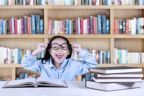 Udane uczennica, podnoszenie rąk w bibliotece — Zdjęcie stockowe