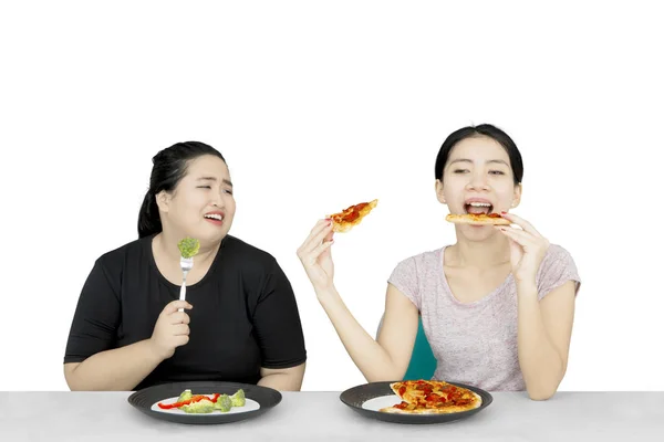 Woman looking at her friend eats pizza — Stock Photo, Image