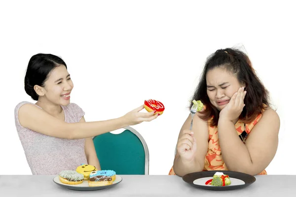 Mujer ofrece donuts a amigo obeso — Foto de Stock