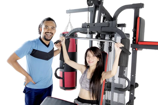 Young woman and her friend with weight machine — Stock Photo, Image