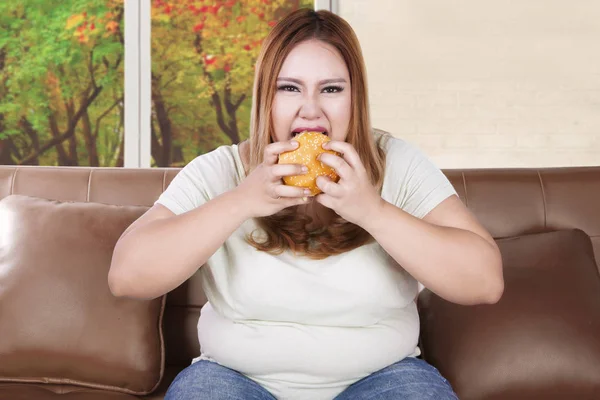 Mujer joven come hamburguesa — Foto de Stock