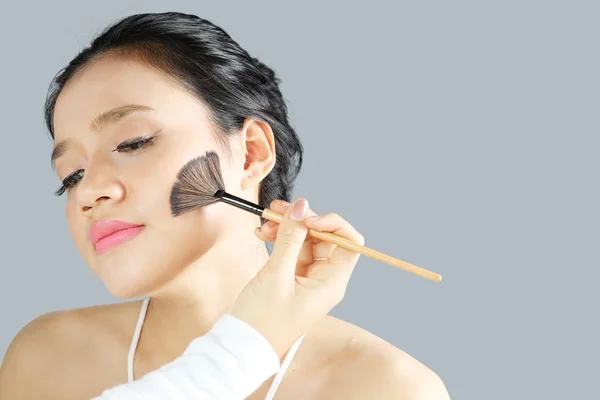 Ung kvinna är tillämpad makeup av makeupartist — Stockfoto