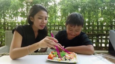 Anne ve çocuk restoranda suşi yiyor