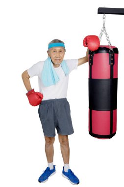 Yaşlı adam bir boks torbası duruyor