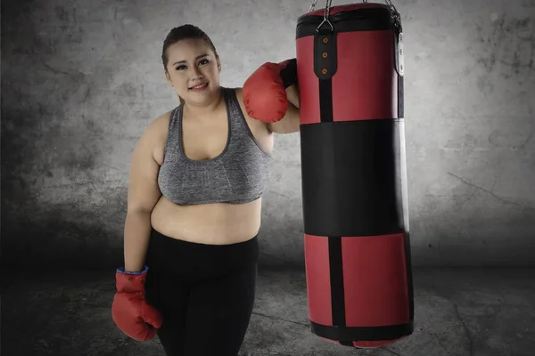 Grosse femme debout près d'un sac de boxe — Photo