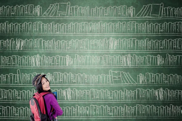 Female student with big bookshelf — Stock Photo, Image