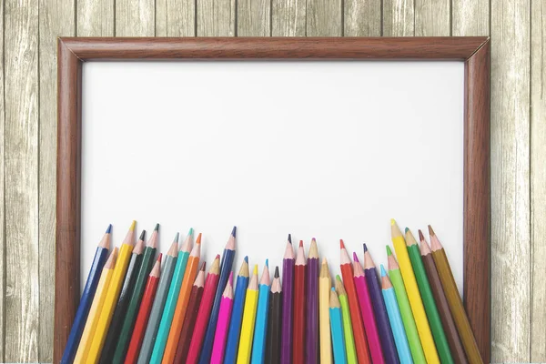 Veelkleurige potloden boven een leeg frame — Stockfoto