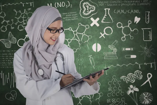 Muslim doctor with clipboard and scribbles — Stock Photo, Image