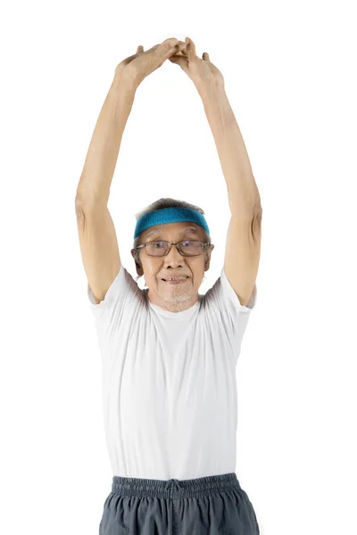 Vecchio uomo stretching mani su studio — Foto Stock