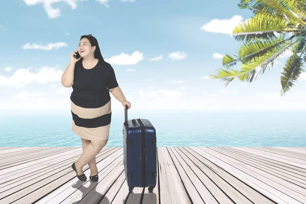 Надмірна вага жінки з валізою на дрібній — стокове фото