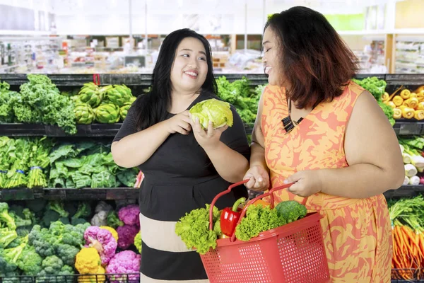 Due donne grasse che comprano verdure fresche — Foto Stock