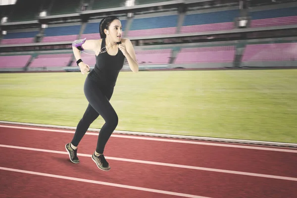 Jovem mulher correndo no estádio — Fotografia de Stock