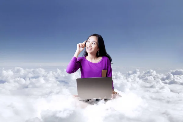 Mujer joven con portátil bajo el cielo azul — Foto de Stock