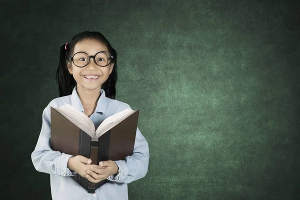 Schoolmeisje glimlachend met boek — Stockfoto