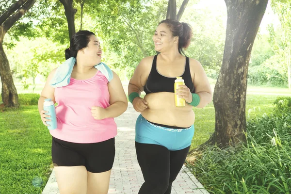 Übergewichtige Frauen joggen im Park — Stockfoto