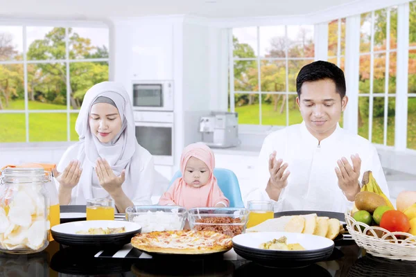 Família muçulmana rezando juntos na mesa de jantar — Fotografia de Stock