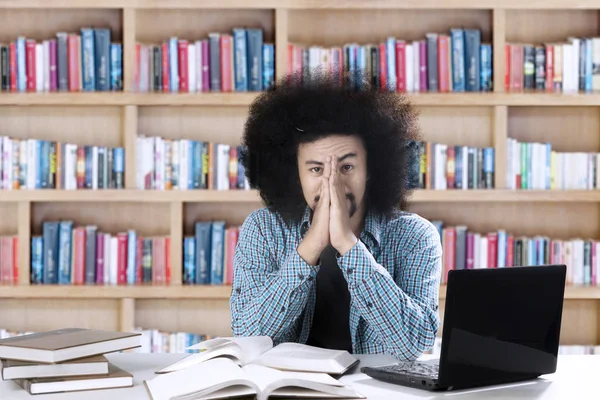 Male student looks tired in the library — Stock Photo, Image