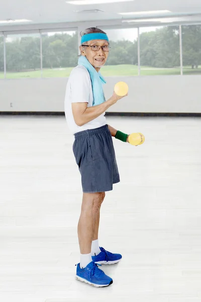 Anciano entrenando con dos pesas — Foto de Stock