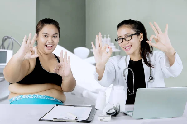 Asiatiska läkare och fet patient visar Ok tecken — Stockfoto