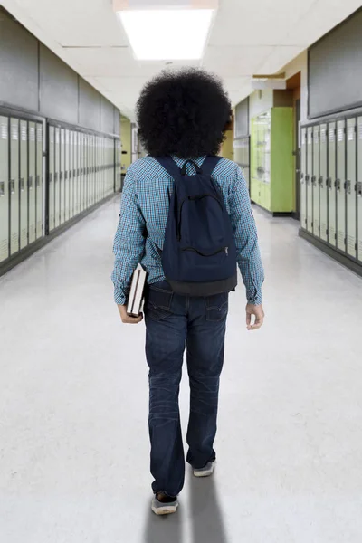 Afro estudiante caminando en el pasillo de la escuela —  Fotos de Stock