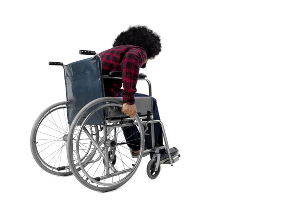 Afro hombre caminando con una silla de ruedas en el estudio —  Fotos de Stock