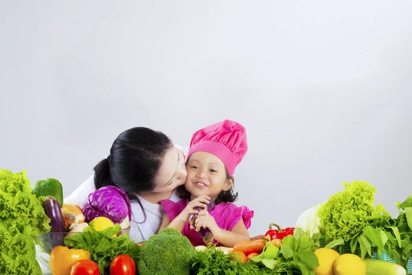 Entzückendes Mädchen und Mutter mit Gemüse — Stockfoto