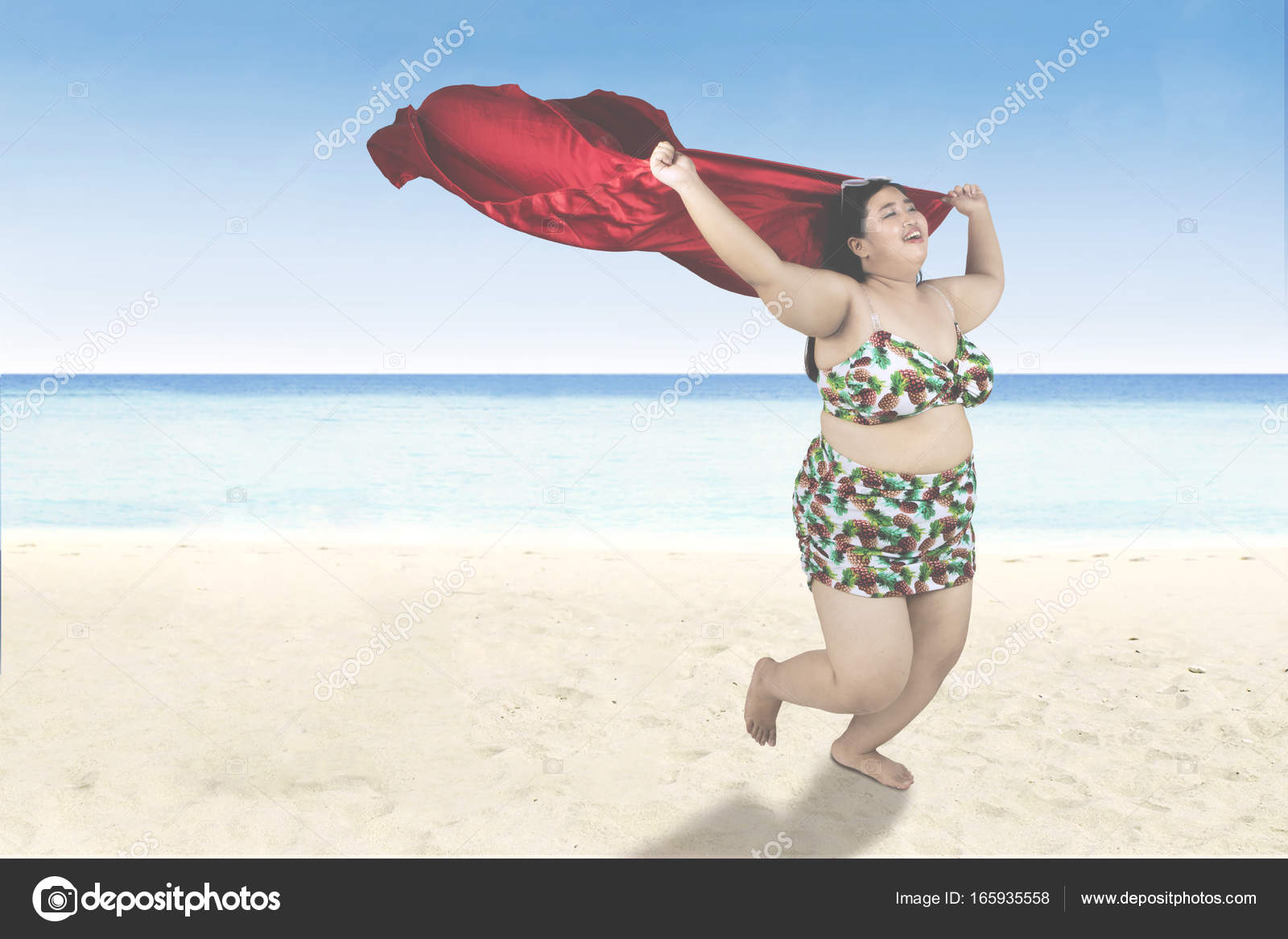 Femme obese avec echarpe court sur la plage Photo de stock par realinemedia 165935558