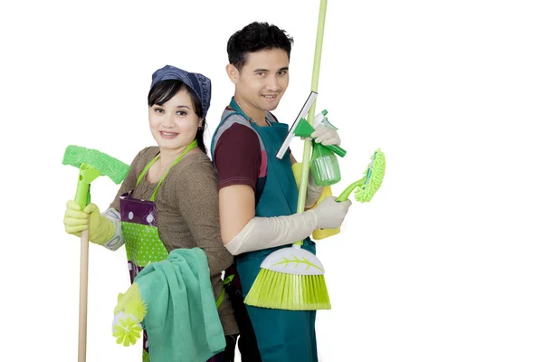 Young couple holding cleaning supplies on studio — Stock Photo, Image