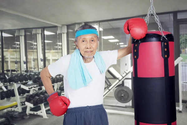 Senior bokser z worek bokserski w centrum fitness — Zdjęcie stockowe