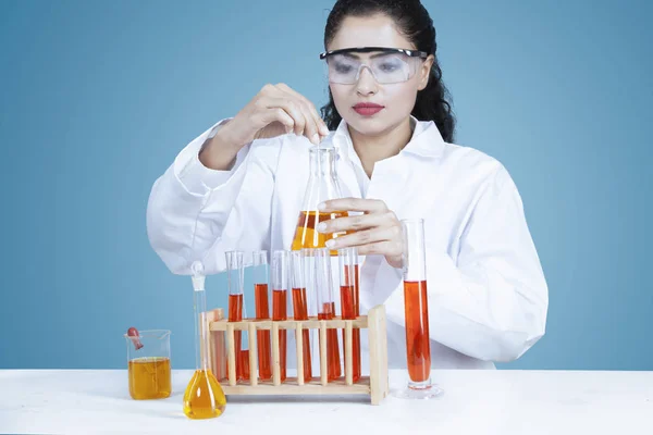 Výzkumník drží chemické kapaliny ve zkumavce — Stock fotografie